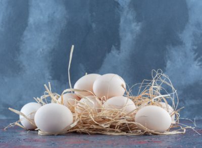 Fresh white and brown chicken eggs with hay . High quality photo